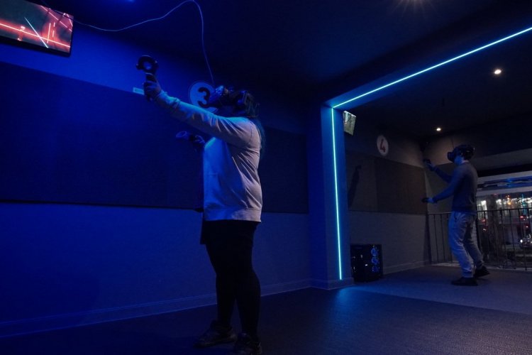 Avec le casque sur la tête en train de jouer à Beat Saber - © Virtuel Center Montparnasse