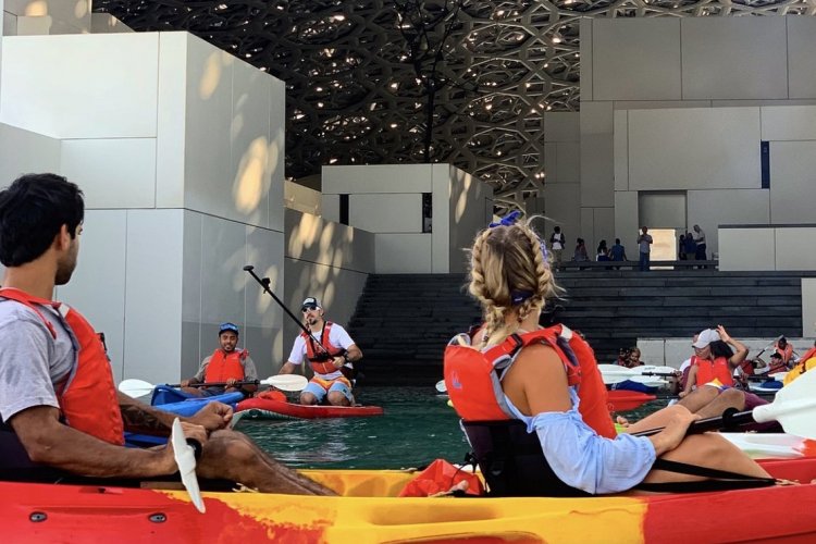 2. Découvrir le Louvre Abu Dhabi autrement : kayak et yoga sous le dôme. Depuis l’année dernière, le Louvre Abu Dhabi se découvre aussi depuis la mer : au petit matin ou au coucher du soleil, les visiteurs peuvent prendre place dans un kayak et partir sur l’eau à la découverte de l’architecture du musée signé Jean Nouvel. Semblant « posé » sur l’eau, le musée laisse la mer pénétrer sous le dôme principal à plusieurs endroits, donnant ainsi lieu à une visite des plus insolite du Louvre des sables. Une fois la balade en mer terminée, les visiteurs peuvent aller profiter des collections extraordinaires du musée ou bien se restaurer au Fouquet’s Abu Dhabi. L’esplanade sous le dôme, point central du musée baigné par la fameuse « pluie de lumière » crée par Jean Nouvel, sera aussi le théâtre à partir de 2021 de cours de yoga. - © visitabudhabi