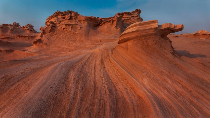 6. S’émerveiller devant les dunes fossiles d’Al Wathba Le désert du Rub al Khali, ou « quart vide », constitue la plus vaste étendue de sable ininterrompue au monde. Il est aussi au cœur de la culture et de l’histoire d’Abu Dhabi, témoin de traditions intemporelles comme la fauconnerie ou l’élevage de chameaux. Véritable paysage de dunes ocres se déployant à l’infini, le désert d’Abu Dhabi se caractérise par son relief, certaines de ses dunes comme celle de Tel Moreeb dépassant les 300 mètres de haut. Mais pour découvrir une véritable curiosité naturelle, il faut se rendre dans la portion de désert autour d’Al Wathba. Différant du sable meuble et des courbes changeantes de la crête des dunes, le désert d’Abu Dhabi abrite aussi des formations de sables durcies, érodées et façonnées petit à petit par les vents. Les dunes fossiles d’Al Wathba se présentent ainsi comme un champ de figures fossilisées aux formes uniques et étonnantes, qui peuvent rappeler par certains côtés le sud-ouest américain. Pour profiter d - © visitabudhabi