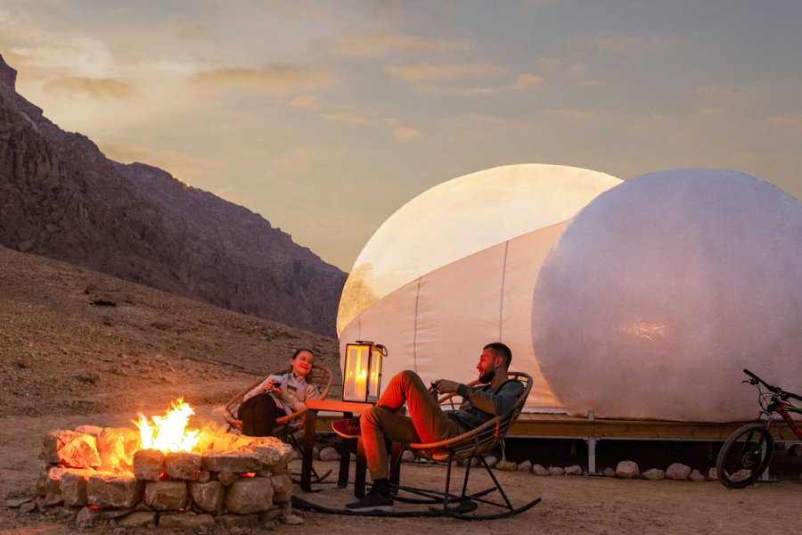 1. Jebel Hafit Desert Park.
Au Sud du pays, à la frontière avec le Sultanat d’Oman, se trouve la montagne du Jebel Hafit qui abrite sur ses pentes des sites archéologiques vieux de plus de 5000 ans, classés au patrimoine mondial de l’UNESCO. Ouvert cette année, la zone protégée du Jebel Hafit Desert Park permet de profiter des paysages extraordinaires de la région, entre wadis et roches escarpées, nichées entre montagne, désert et palmeraie. Les visiteurs peuvent maintenant y passer la nuit en choisissant parmi différentes options de camping, de la tente bédouine traditionnelle aux bulles de glamping idéales pour profiter du ciel étoilé. La journée, les voyageurs peuvent partir en randonnée, s’essayer au vélo-cross, explorer la région à cheval ou remonter le temps en découvrant des tombes préservées datant du Néolithique.