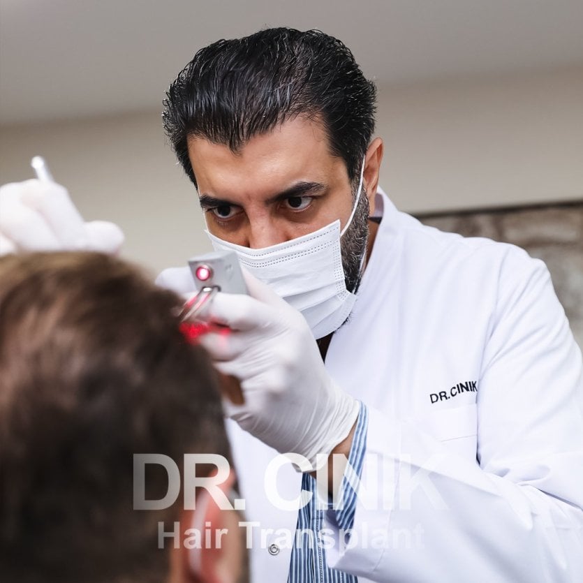 Le docteur cinik en opération de greffe des cheveux - © DR