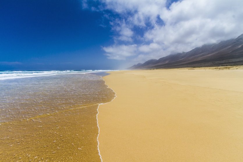 Amateur beach nudists stretching on the golden sand