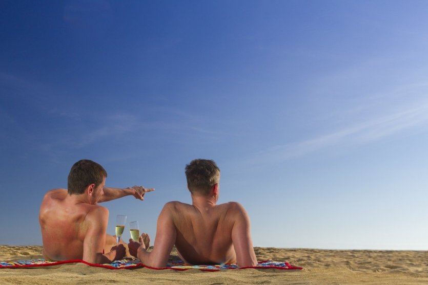 Amateur beach nudists stretching on the golden sand