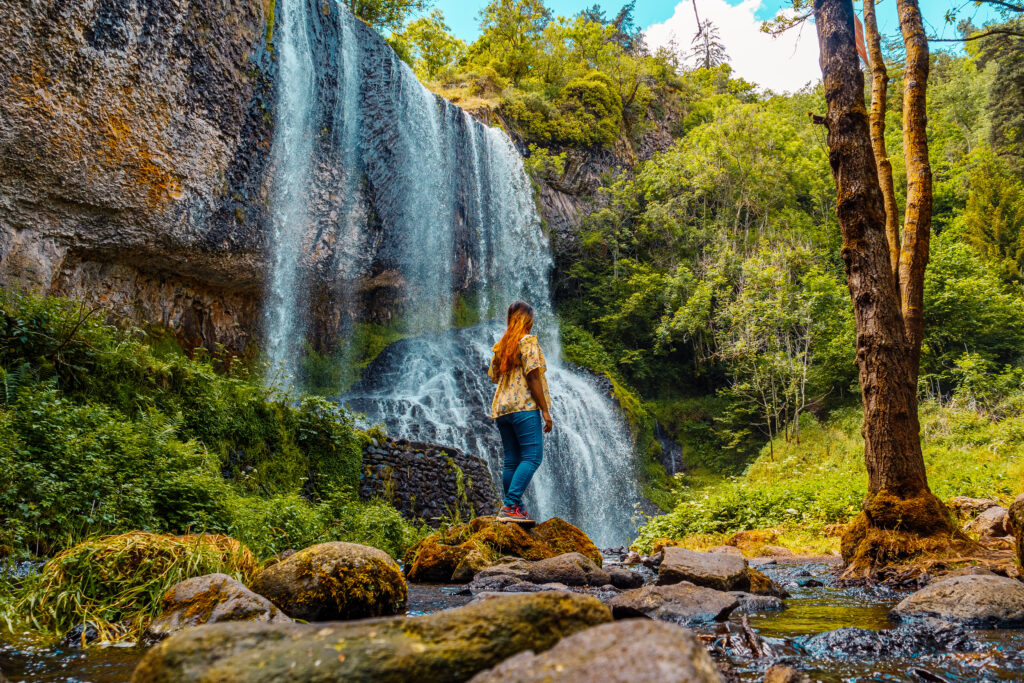Jeune femme devant la cascade de la Beaume
