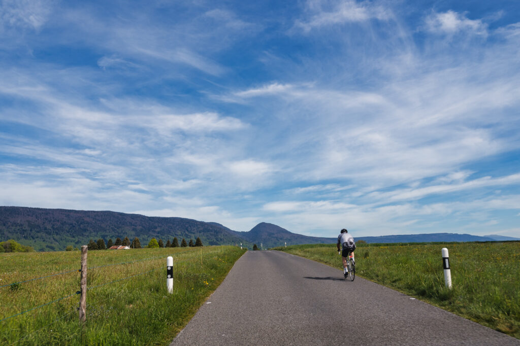 Cycliste sur une route de campagne dans le Jura
