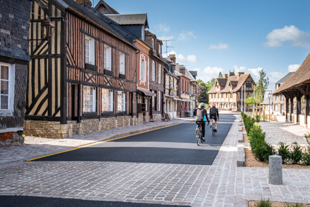 Centre ville de Beuvron-en-Auge avec des cyclistes