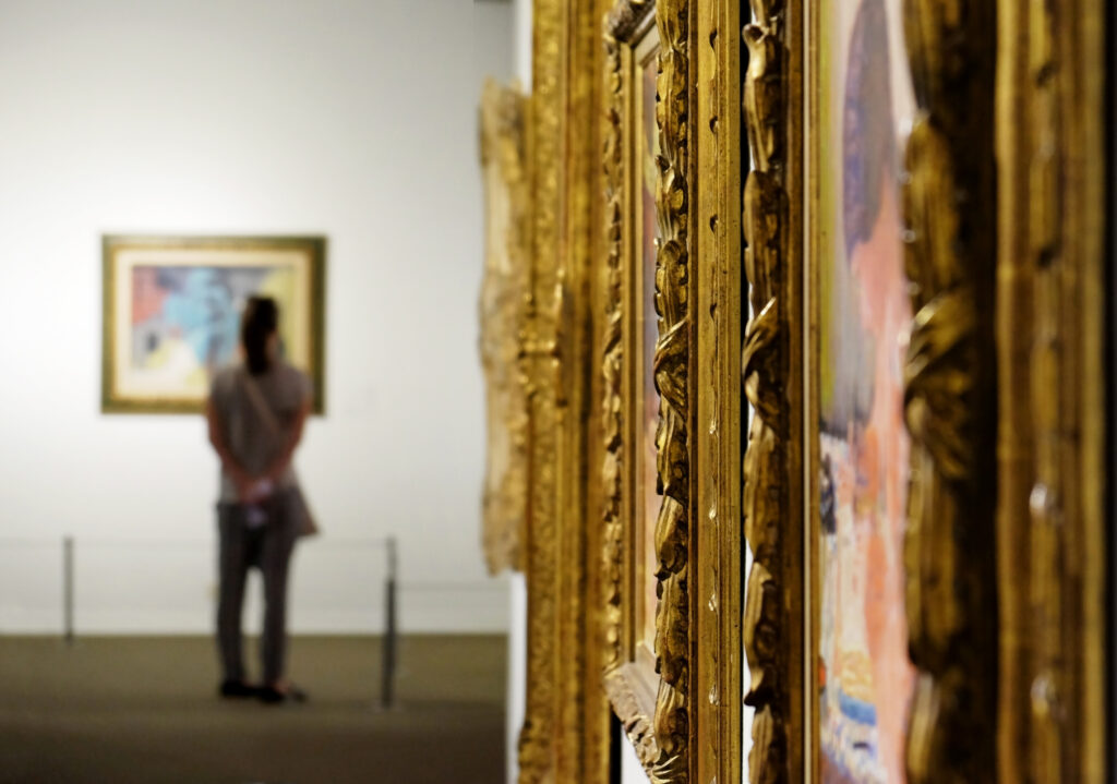 Une fille regarde des tableaux dans un musée