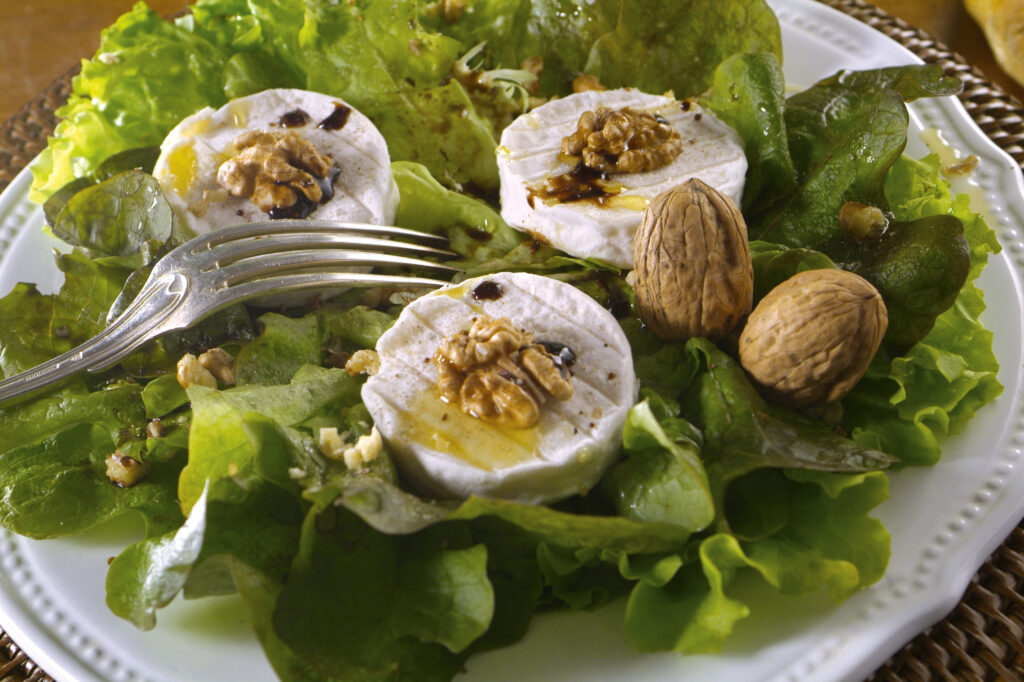 Fromages de chèvre Rocamadour AOC sur lit de salade, noix et miel