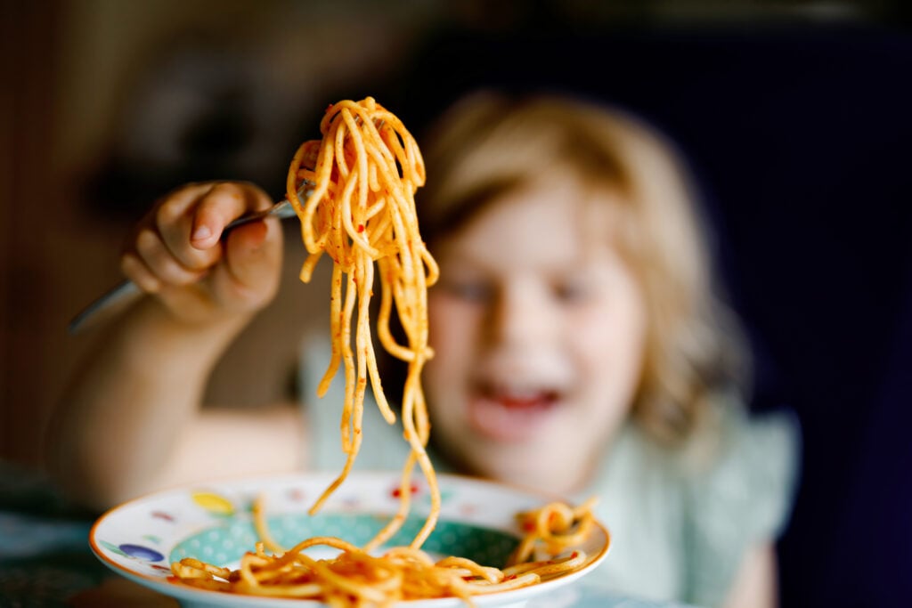 Petite fille mangeant des pâtes