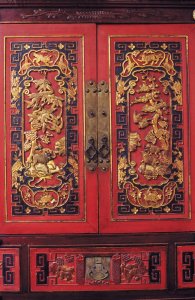 Meuble en bois aux sculptures représentant la faune et la flore chinoises.