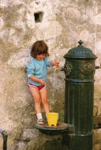 <p>Jeune fille s'amusant avec une fontaine de Porto.</p>