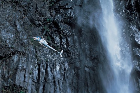 Hélicoptère longeant la cascade du Trou de Fer. (© D. Cati - Iconotec)