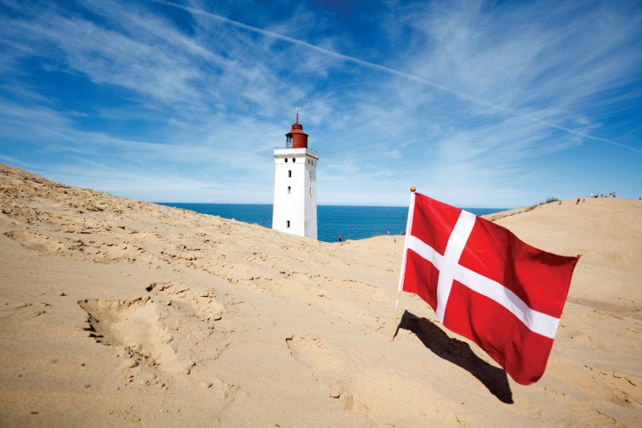 Phare de Rubjerg Knude et drapeau danois. PhotographerCW - iStockphoto.com