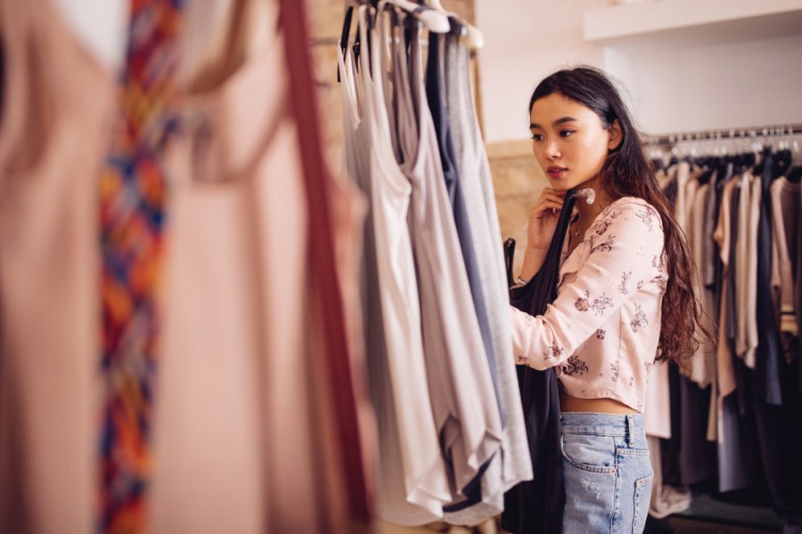 Beautiful young asian woman browsing and looking to buy summer clothes in a women's boutique wundervisuals - iStockphoto.com