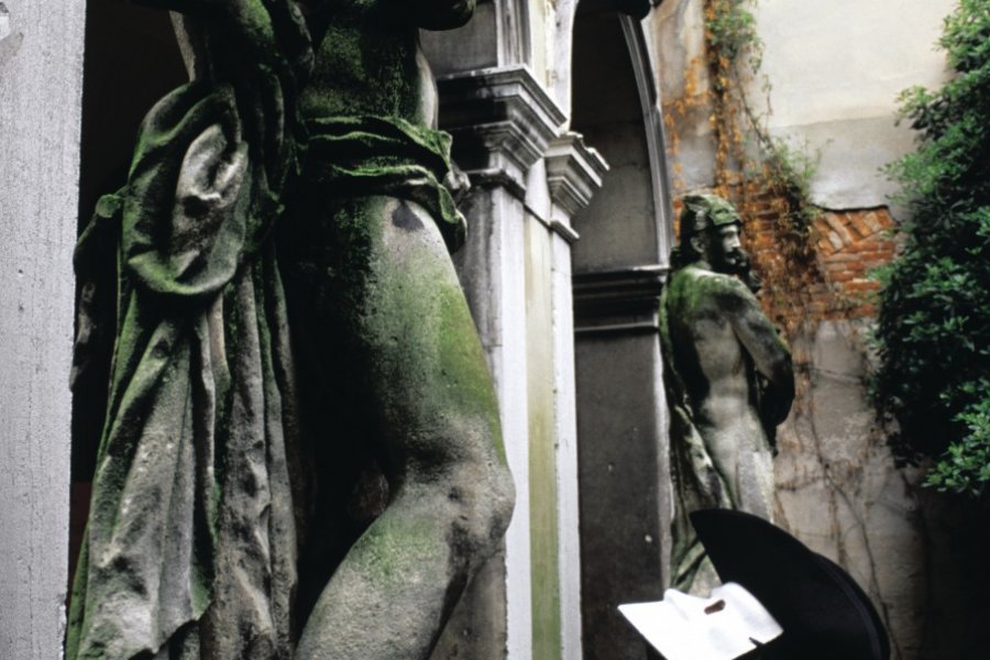 Homme masqué regardant une sculpture. (© Itzak Newmann - Iconotec))