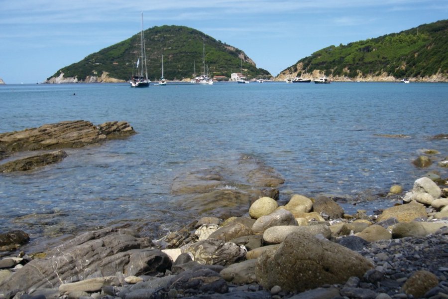 Plage de galets lisses et de rochers, baignée d'une eau cristalline, à Enfola. Muriel PARENT